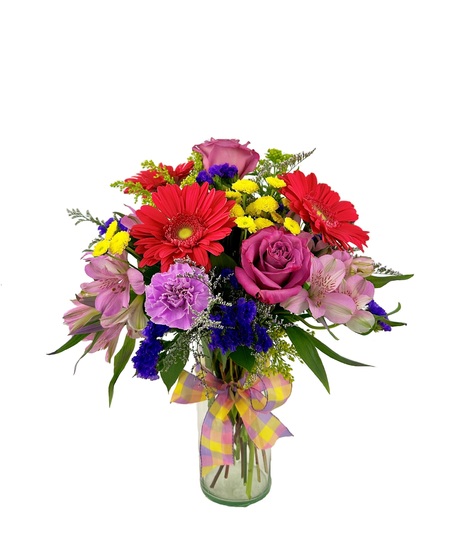 Bright and colorful flowers are arranged in a cylinder vase. 