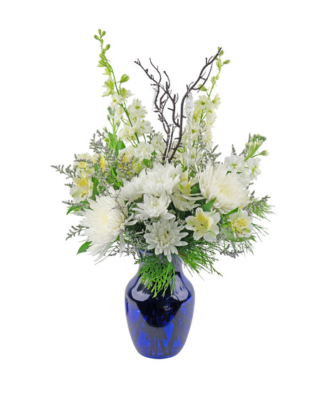 A winter inspired bouquet of white flowers in a blue vase.  