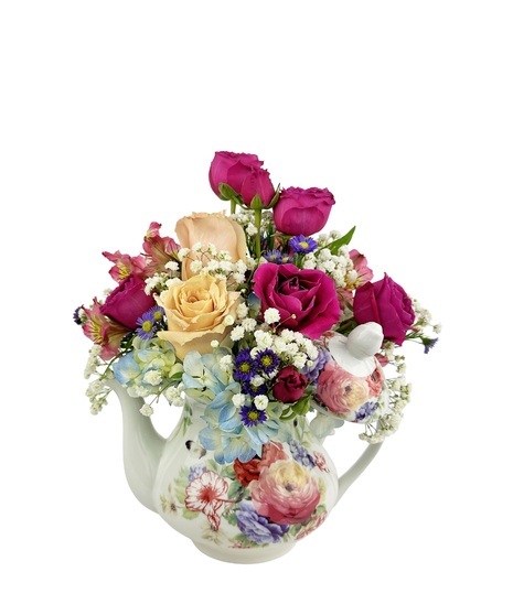 Mixed flowers arranged in either a tea cup or tea pot.