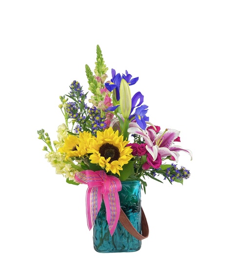 Tall stems of vibrant colored flowers in a rectangle vase.