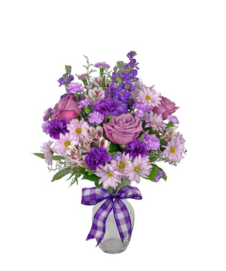 A bouquet of purple stock, mini carnations, alstromeria, and caspia in a clear glass ribbed vase and tied with a purple plaid ribbon