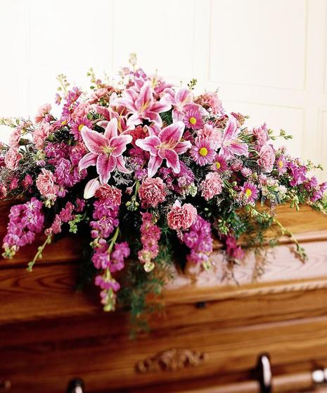 Pink casket spray of stargazer lilies, daisies, caspia and greenery.