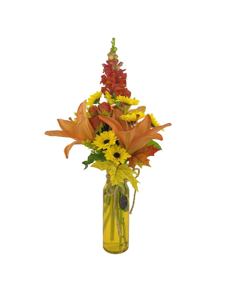 red, orange and yellow flowers in a fall toned glass vase accented with a metal acorn